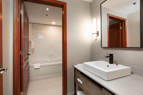 蒙特朗布朗御峰园德内格斯酒店的浴室设有白色水槽和镜子