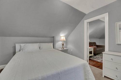 哈里斯堡Suites on Seneca - Gorgeous One Bedroom Apartment的卧室配有白色的床和镜子