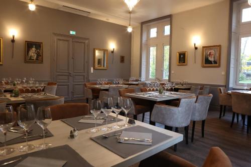 Cosne-dʼAllierChâteau de Petit Bois的配有桌椅和酒杯的餐厅