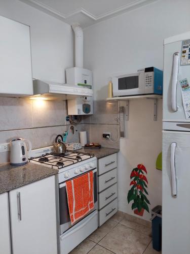 布兰卡港Departamento Viamonte con cochera的厨房配有炉灶和微波炉。