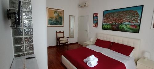 塔兰托Casa Flora的一间卧室配有红色和白色枕头的床