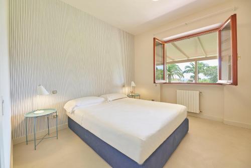 卡波利韦里Villa Elle Exclusive Isola d'Elba的卧室设有一张白色大床和一扇窗户。
