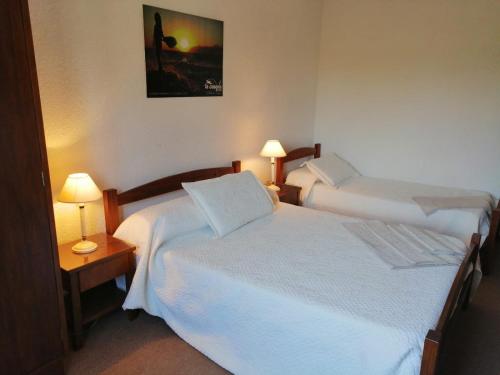 拉帕洛马Hotel La Casona的配有2盏灯的酒店客房的2张床