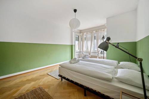 苏黎世Central Apartment for City Explorers 224的一间卧室设有一张床和绿色的墙壁