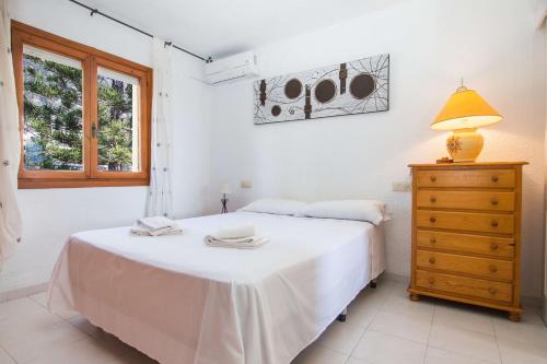 卡尔佩Villa Erik - PlusHolidays的卧室配有白色的床、梳妆台和台灯。