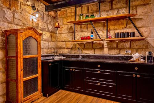 迈季代勒舍姆斯snowflake.golan的厨房配有黑色橱柜和石墙