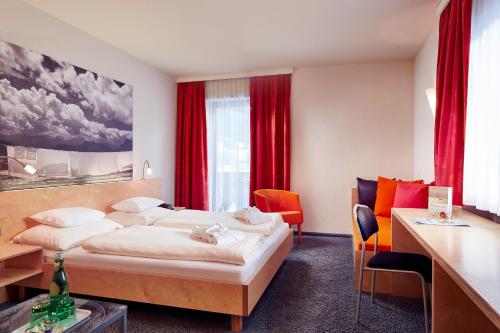 莱尔莫斯Loisach Smarthotel by keyone的酒店客房,配有床和红色窗帘