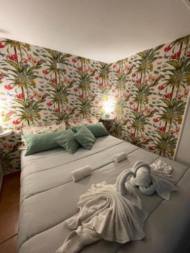 那不勒斯Guarracino P. Capodimonte Suite的一间卧室配有一张带棕榈壁纸的大床