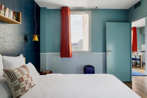 巴黎巴黎凡尔赛门展览中心艾佳套房酒店的卧室配有白色的床和蓝色的墙壁