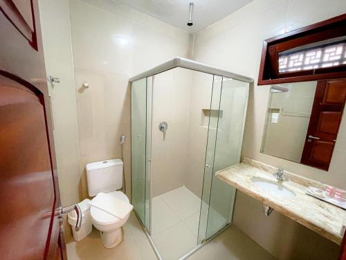 雅帕拉廷加Pousada San Giovanni的一间带卫生间和玻璃淋浴间的浴室