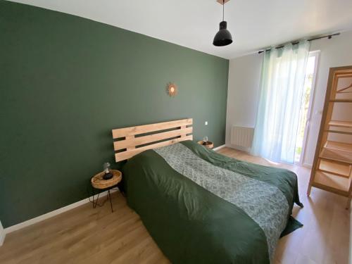 阿卡雄Charmant T2 avec extérieur Villa Deganne的一间卧室设有绿色的墙壁和一张床