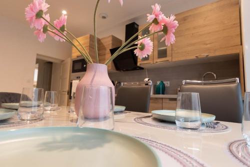 马孔Cabana & La Cascade的一张桌子,上面有花瓶,上面有粉红色的花