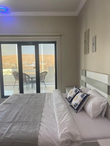 Al WāşilHome X4的一间卧室设有一张床,享有阳台的景色