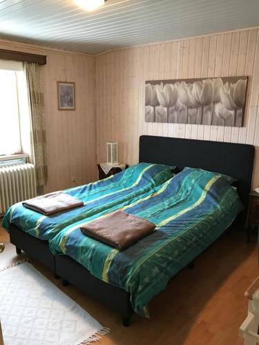 弗朗科尔尚Beau-sejour的一间卧室配有一张带蓝色棉被的大床