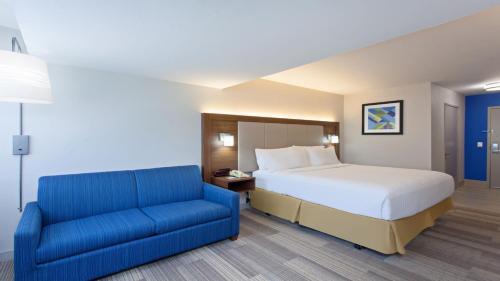 米拉梅萨圣地亚哥 - 米拉梅萨智选假日酒店的一间卧室配有一张床和一张蓝色的沙发