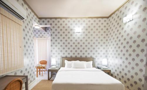 斋沙默尔索纳尔哈维里酒店的卧室配有一张床和一张桌子及椅子