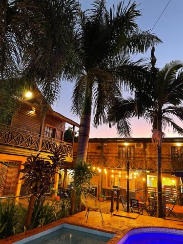 伊瓜苏港Tierra Viva的一座带游泳池、棕榈树和大楼的度假村
