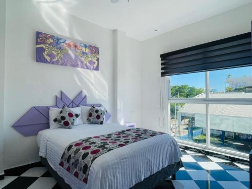普拉亚卡门WINDAY HOTEL - Cerca 5a Avenida的一间卧室设有一张床和一个大窗户