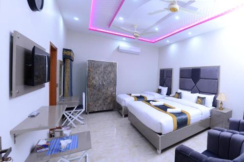 拉合尔Hotel Grand Lahore的一间卧室配有一张床、一张书桌和一台电视。