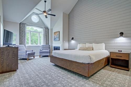 东斯特劳兹堡Pocono Mountain Villas by Exploria Resorts的一间卧室配有一张床、一台电视和一把椅子