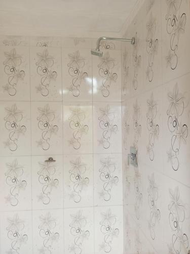 塔里哈Cómo en casa的浴室设有淋浴,墙上有银色的漩涡浴缸。