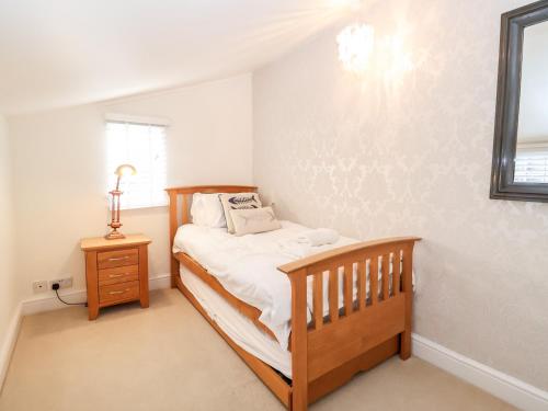 绍斯沃尔德4 East Green, Southwold的一间卧室配有一张床和一张木床