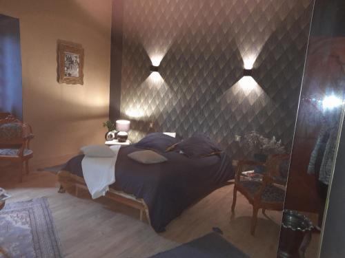 Saint-Germain-lès-Arlaychambre du jura的卧室配有一张大床,墙上有灯