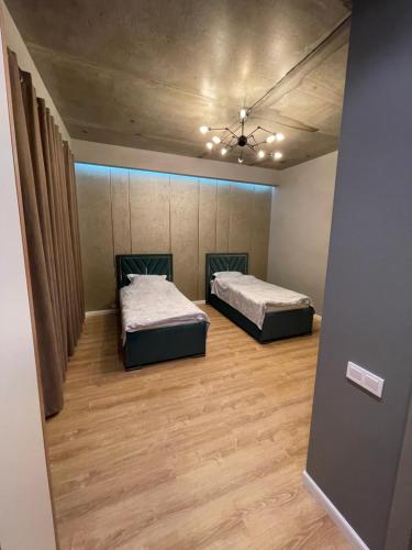 阿克套Apartment Florence моря 600 метров的配有两张床的客房铺有木地板。
