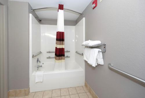 卡罗尔顿Red Roof Inn & Suites Carrollton, GA - West Georgia的设有带浴缸和淋浴的浴室。