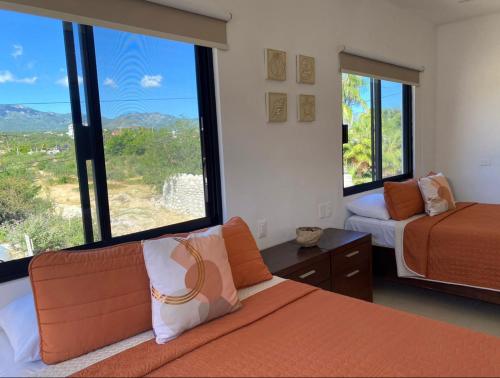 La Ventana帕拉伊索别墅酒店的一间卧室设有两张床和大窗户