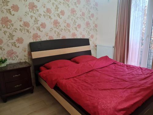 第比利斯Saburtalo的一间卧室配有一张红色棉被的床