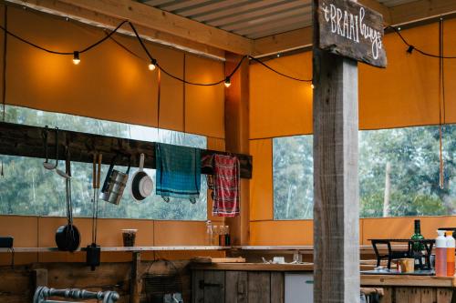NistelrodeKampeerbeleving Dijksehoeve的餐厅拥有橙色的墙壁和窗户,设有柜台