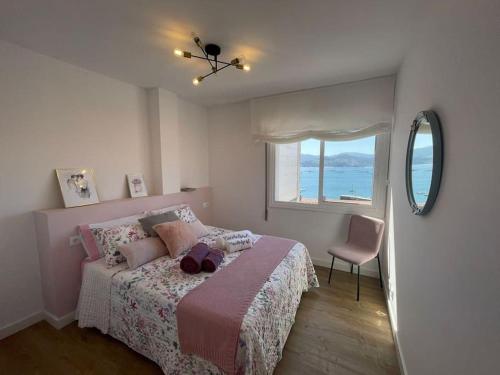 庞特维德拉Covelodge - Piso a pocos metros de la playa的一间卧室配有一张带窗户和椅子的床