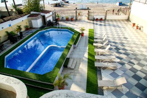 罗安达Brisotel - Beira Mar的享有带椅子的游泳池和海滩的顶部景色