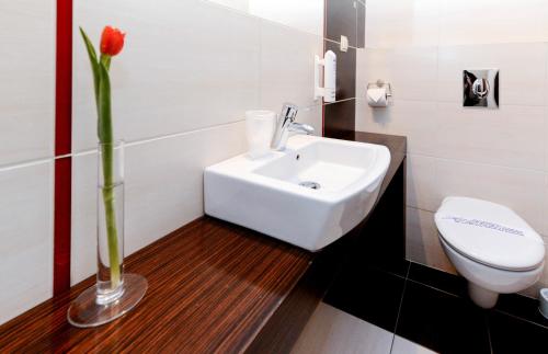 切申Hotel Liburnia的浴室设有白色水槽和红色花瓶