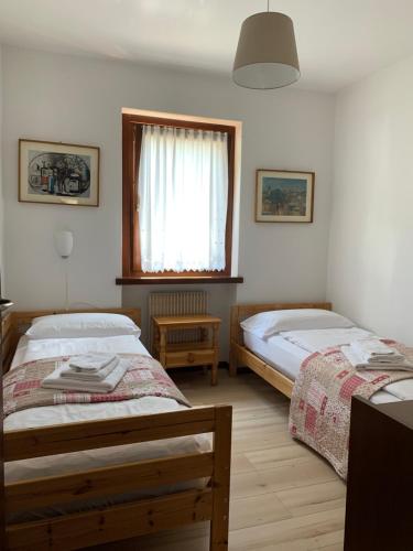 平佐洛Residence Alpen Casavacanze的一间卧室设有两张床和窗户。
