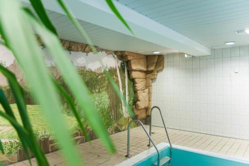 永斯多夫Hotel Gondelfahrt的一间设有一座石墙游泳池的客房