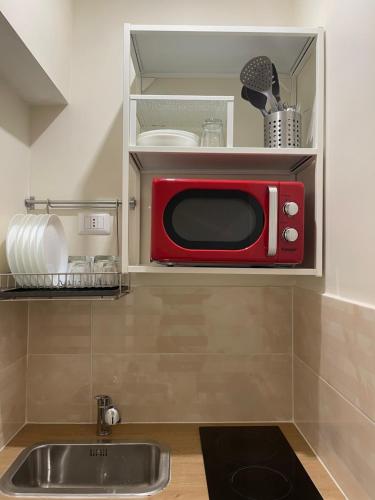 那不勒斯La Dimora Dei Sogni的带水槽的厨房内的红色微波炉