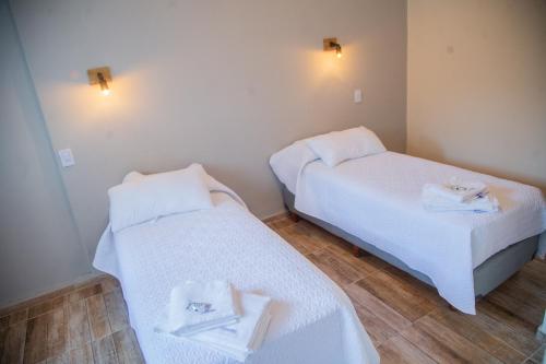 圣胡安Hotel Anmara的配有2张床的客房内配有白色床单和毛巾