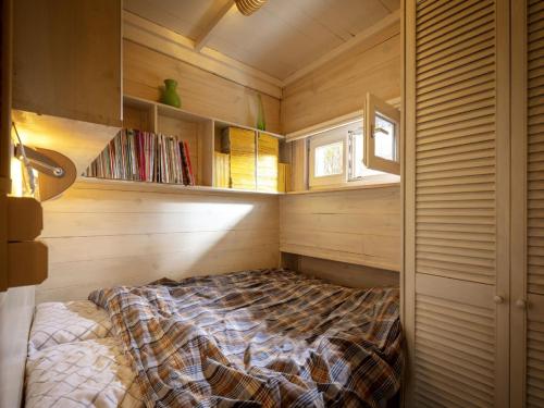 LilleTranquil bungalow in Lille with garden的卧室配有一张床铺,位于带木墙的房间内