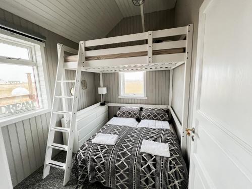 GardurGarður Apartments的配有梯子的小客房内的双层床