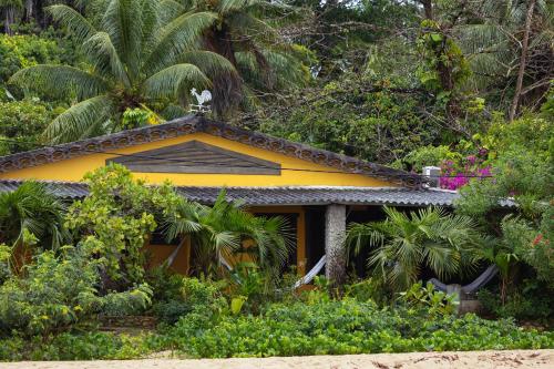 伊尔哈德博伊巴Pousada Pouso da Maré的花园中的一个黄色房子