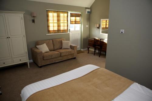 滕特登布尔旅馆的一间卧室配有一张床、一张沙发和一把椅子