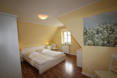 宾茨Haus Godewind的卧室配有一张床,墙上挂有绘画作品