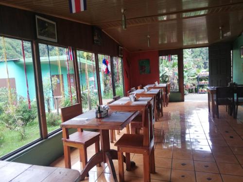 圣赫拉多德多塔Cabañas San gerardo的餐厅的一排木桌,窗户