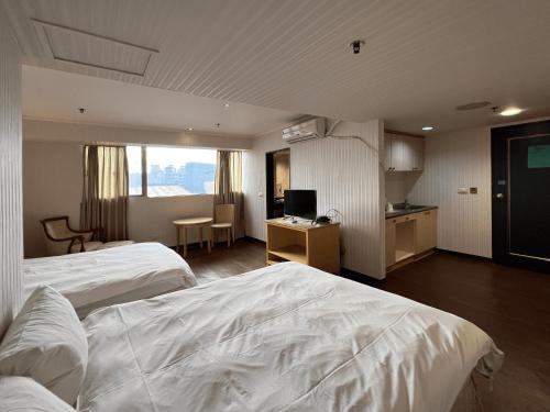 新竹荷米斯饭店 的酒店客房设有2张白色的床和厨房