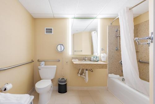 奥马哈Wyndham Omaha Hotel - West Dodge的浴室配有卫生间、盥洗盆和浴缸。