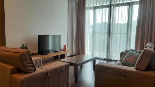 金马仑高原G Residence - 3R2B The Retreat, Aranda Nova, Cameron Highlands的客厅配有2把椅子和平面电视