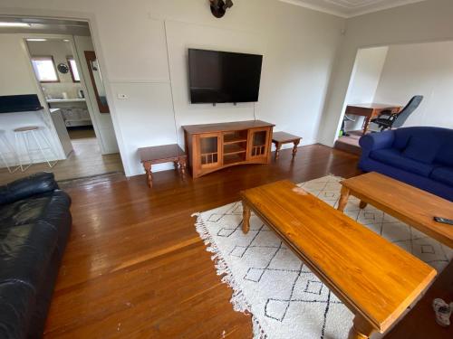 卧龙岗Normandie Wollongong的带沙发、桌子和电视的客厅