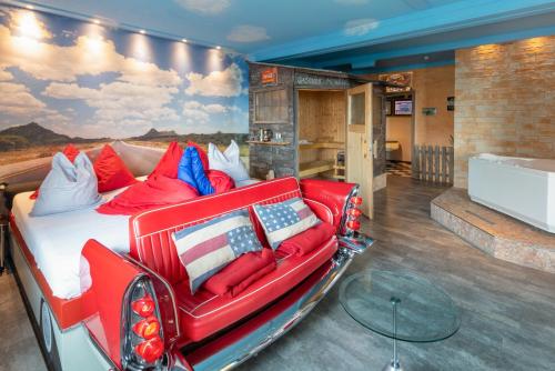 贝阿滕贝格Hotel Zeit & Traum的一张位于红色沙发的房间的床铺